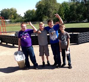 5th grade boys showing civility by offering to pick up trash on the playground.