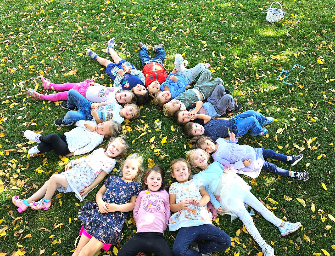 Preschoolers laying in grass